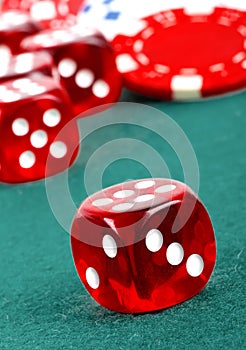 Red dice on a casino table with chips