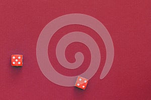 Red dice on a dark red background. Gambling concept, top view