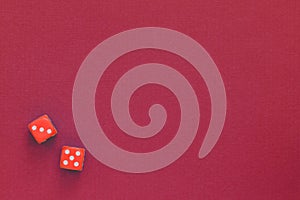 Red dice on a dark red background. Gambling concept, top view