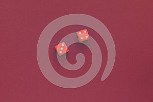 Red dice on a dark red background. Gambling concept, top view