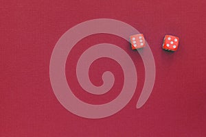 Red dice on a dark red background. Gambling concept, top view
