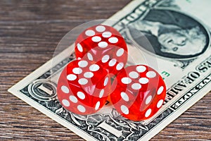 Red dices with one dollar banknote on wooden table