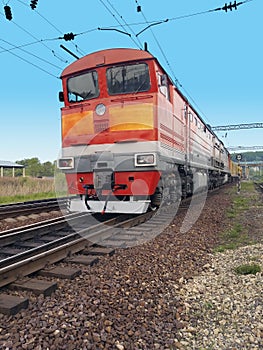 Red diesel locomotive on the tracks in motion