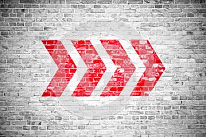 Red directional arrow signs pointing direction painted on a white gray brick wall signboard texture background