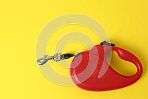 Red dog retractable leash on yellow background, top view. Space for text