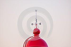 Red dome of the Ponta da Piedade lighthouse, with a wind vane on top. Algarve, Portugal