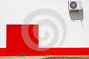 Red door and an airconditioner on the wall