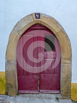 red door with arch in the warhead of Judiaria in the Alentejo locality of Castelo de Vide.Portugal