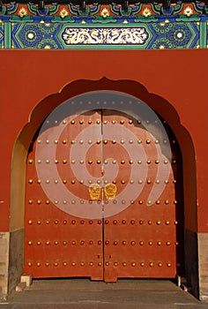A red door with Chinese decoration at the Temple of Heaven in Beijing, China. Known as Tiantan in Chinese.