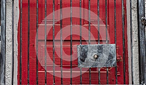 Red door frame behind steel grid closed entrance textured background