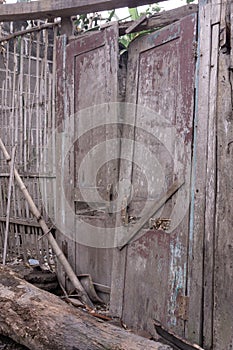 a red door on an old building that looked frail was taken in the morning.