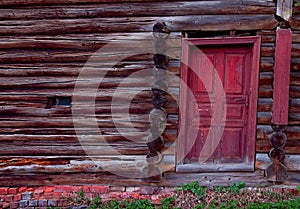 Red door in an old log wall