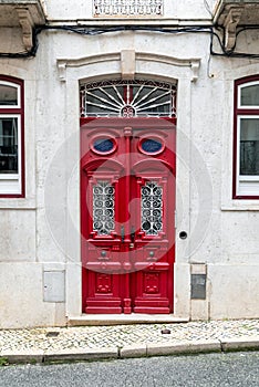 Red door with ornate iron work in European neighborhood