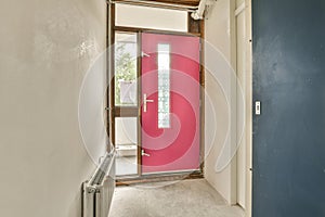 a red door in a white room with a window