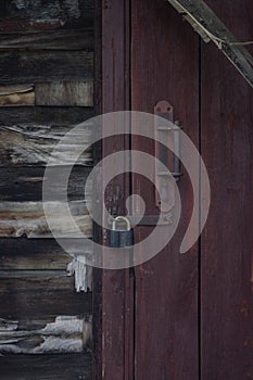 Red door and wooden wall. old padlock on the old door