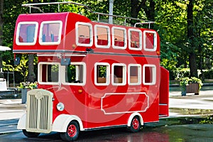 The red double-decker bus in city park