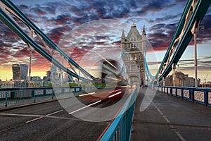 Red double decker bus crossing the Tower Bridge in London