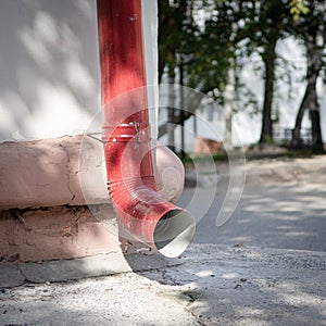 A red downpipe by the white wall