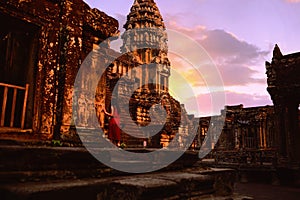 A red dress girl staring at the ancient Angkor Wat photo