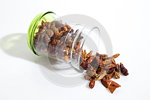 Red dried hot peppers in a jar isolated in a white background