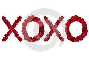 Red dried rose petals arranged into xoxo