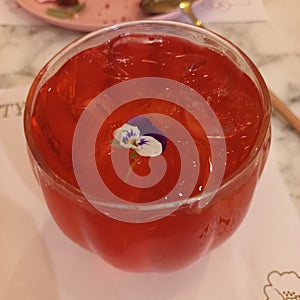 Red drink cocktail with edible flower