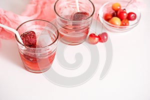 Red drink with ice, mint leaves and strawberry. Cocktail making bar tools