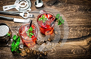 Red drink with ice, mint leaves and strawberry. Cocktail