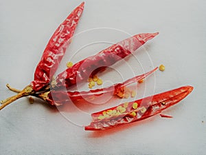 Red dry chillies with half opened and yellow seeds.