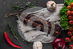 Red dry homemade sausage on a dark background