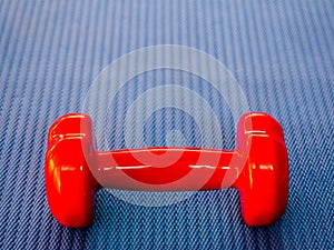 Red dumbbell on blue Mat for fitness or yoga