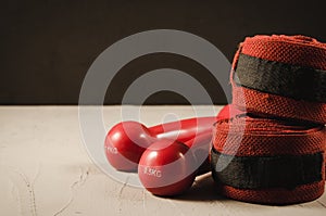 red dumbbells and bandage/red dumbbells and bandage on a black background. Selective focus and copyspace