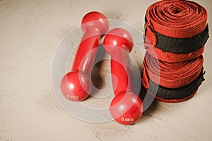 Red dumbbells and bandage/red dumbbells and bandage on a stone background. Top view and copyspace