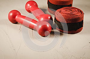 red dumbbells and bandage/red dumbbells and bandage on a white stone