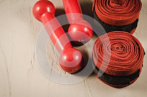 Red dumbbells and bandage/red dumbbells and bandage on a white stone. Top view and copyspace