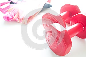 Red dumbbells and sport wear in fittness background. Sport wear, Sport fashion, Sport accessories, Sport equipment.