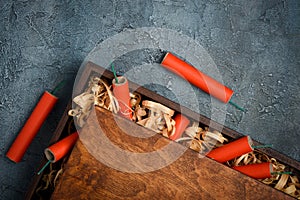 Red dynamite tnt firecrackers fuse in wooden box crate with wooden straw shavings