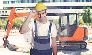 Red earthmover with handsome latin american construction worker