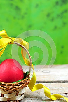 Red easter egg in basket with ribbon
