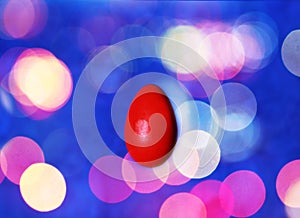 Red easter egg on colorful abstractlights background. Bokeh