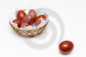 a red easter egg lies on the background of a basket with eggs