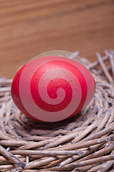 Red easter egg in a wooden nest