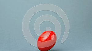 Red egg revolving against grey background