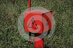 red electric cable stands in the field