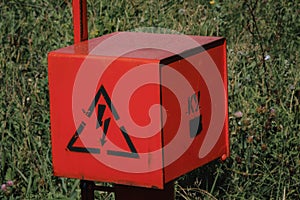 red electric cable stands in the field