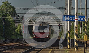 Red electric engine with fast slovakia train near Brno city in summer morning