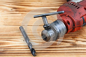 Red Electric hand drill set on wooden table
