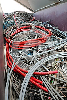 red electrical cord and many other tangled used electrical cords in landfill for recycling copper