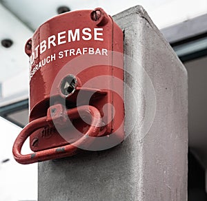 Red emergency brake to stop a large rolling staircase, with German inscription