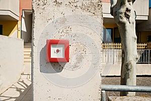 Red emergency button on stone pillar outdoors